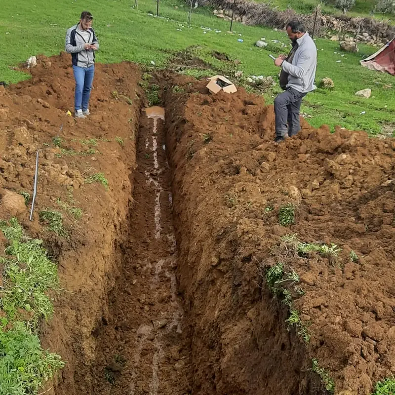 Geologists examining a trench opened for active-fault investigation