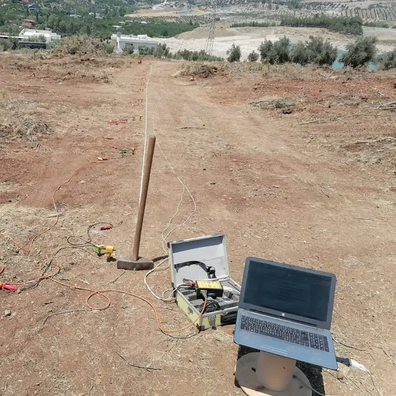Seismic survey with a survey line laid out in the field, a sledgehammer, and a recording computer