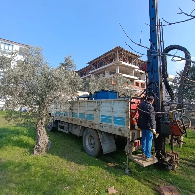 Truck-mounted drilling rig working within a parcel next to a residential construction site